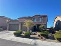 Charming home with a two car garage, desert landscaping, and solar panels on the roof at 2176 De Narvik Dr, Henderson, NV 89044