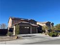 Two story home featuring a three car garage, long driveway and desert landscaping at 2176 De Narvik Dr, Henderson, NV 89044