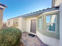 Inviting front entrance with a neutral color scheme, a tiled walkway, and manicured landscaping at 2241 Chandler Ranch Pl, Laughlin, NV 89029