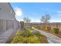 Landscaped backyard featuring desert flora with mountain views and a wrought iron fence at 2493 Verdello St, Henderson, NV 89044