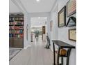 Bright hallway featuring tile flooring, neutral paint and custom bookshelves at 3037 Villanelle Ave, Henderson, NV 89044