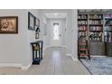 Inviting entryway with tiled floor leading to a study with custom built-in bookshelves and cabinets at 3037 Villanelle Ave, Henderson, NV 89044