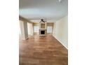 Spacious living room with wood floors, neutral paint, modern ceiling fan, and a fireplace at 3177 Rabbit Creek Dr, Las Vegas, NV 89120