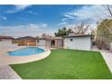 Backyard featuring a sparkling pool, lush lawn, and covered patio, perfect for outdoor entertaining at 4412 Denia Cir, Las Vegas, NV 89108