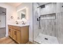 Bright bathroom showcasing a double vanity, a glass-enclosed shower with vertical tiles, and modern fixtures at 4412 Denia Cir, Las Vegas, NV 89108