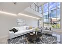 Bright, modern living room boasts soaring windows offering city views, complemented by stylish, neutral decor at 4515 Dean Martin Dr # 201, Las Vegas, NV 89103