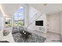 Bright living room featuring tall windows and a minimalist floating staircase with cable railings at 4515 Dean Martin Dr # 201, Las Vegas, NV 89103