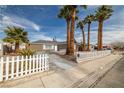 Single story home with mature landscaping, large yard, and a white picket fence at 4606 Cory Pl, Las Vegas, NV 89107