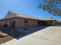 Single-story brick home with large driveway with partial desert landscaping on a sunny day at 4911 W Pebble Rd, Las Vegas, NV 89139