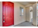 Close-up of the red front door with hardware and a window to the left at 5827 Delonee Skies Ave, Las Vegas, NV 89131