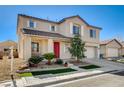 Inviting two-story home with desert landscaping, an attached two-car garage, and a red front door at 5827 Delonee Skies Ave, Las Vegas, NV 89131