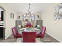 Dining area featuring a glass table, chandelier, and decorative gray chairs at 5832 Ivy Vine Ct, Las Vegas, NV 89141