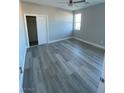 Well-lit bedroom featuring light gray walls, a ceiling fan, and wood-look flooring at 6360 Montclair St, Pahrump, NV 89061