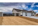 Side view of a new construction home featuring a three car garage and gravel landscaping at 6360 Montclair St, Pahrump, NV 89061