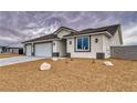 Street view of a new construction home featuring a three car garage and desert landscaping at 6360 Montclair St, Pahrump, NV 89061