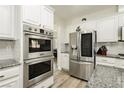 Modern kitchen featuring stainless steel appliances, light gray backsplash, and white cabinets at 6391 Tempting Choice Ave, Las Vegas, NV 89131