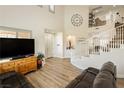 Bright living room features soaring ceilings, a winding staircase, and wood flooring at 6391 Tempting Choice Ave, Las Vegas, NV 89131