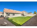 Serene backyard featuring green artificial turf and desert rock landscaping at 8745 Point Kathy Cir, Las Vegas, NV 89147