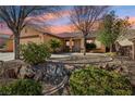 A well-maintained yard with desert landscaping and a mature tree at 1011 Amber Gate St, Henderson, NV 89002