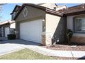 A view of the front exterior of this house with an attached garage at 10321 Birch Bluff Ln, Las Vegas, NV 89145