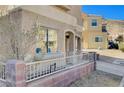 Beige stucco home with covered parking, arched entry, and iron-gated and brick-lined front yard at 10505 Cold Mountain Ave, Las Vegas, NV 89129