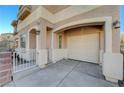 Beige stucco home with covered parking, arched entry, and iron-gated and brick-lined front yard at 10505 Cold Mountain Ave, Las Vegas, NV 89129