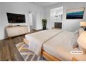 Staged main bedroom with wood-look floors, neutral walls, and ensuite bathroom at 10524 India Hawthorn Ave, Las Vegas, NV 89144