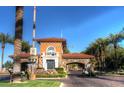 South Shore entrance gate featuring stone archways, tile roof, and desert landscaping at 2 Camino Barcelona Pl, Henderson, NV 89011