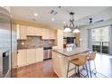 Modern kitchen featuring stainless steel appliances, granite countertops, tile backsplash, and adjacent living area at 2455 W Serene Ave # 603, Las Vegas, NV 89123