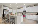Bright kitchen featuring white cabinets, stainless steel appliances, and a stone island with barstool seating at 333 Canary Song Dr, Henderson, NV 89011