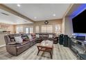 Inviting living room featuring a large sectional sofa, modern flooring, and a stylish entertainment center at 3960 Badgerbrook St, Las Vegas, NV 89129