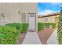 Inviting front entrance with lush greenery, a charming walkway, and a cozy seating area at 5421 Painted Mirage Rd, Las Vegas, NV 89149