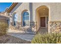 Covered porch features stone accents, arched entryways, and a welcoming front door perfect for guests at 5958 W Agate Ave, Las Vegas, NV 89139