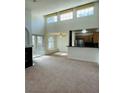Spacious living room with carpet and high ceiling featuring natural light and an open bar kitchen view at 9325 W Desert Inn Rd # 218, Las Vegas, NV 89117