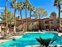 Community pool view in a desert landscape, surrounded by palm trees and plenty of lounge seating at 9325 W Desert Inn Rd # 218, Las Vegas, NV 89117