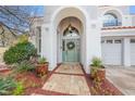 Inviting front entryway featuring a quaint wreath, custom paint and mature landscaping at 1700 Monte Rio Ct, Las Vegas, NV 89128