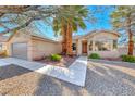 Tan single-story home with attached two-car garage and desert landscaping for low maintenance at 1035 Dodger Blue Ave, Las Vegas, NV 89123