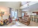 Open-concept living room with high ceilings, wood floors, and a view of the kitchen and dining area at 10431 Kitty Joyce Ave, Las Vegas, NV 89129