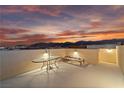 Relaxing rooftop patio featuring a table, bench, and scenic mountain views at sunset at 10725 Wrigley Field Ave, Las Vegas, NV 89166