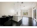 Bright and airy living room with a piano, sleek dark wood floors and modern fixtures at 11 Belfair Ct, Henderson, NV 89052