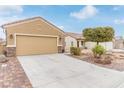 Charming single-story home with a two-car garage, desert landscaping, and a brick-paved driveway at 2404 Garganey Ave, North Las Vegas, NV 89084