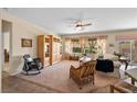 Spacious living room with a ceiling fan, large windows, and comfortable wicker seating at 2467 Moonlight Valley Ave, Henderson, NV 89044