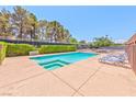 Inviting community pool area featuring a pool, lounge chairs, and mature trees at 2825 E Hacienda Ave, Las Vegas, NV 89120