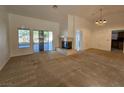 Open living room featuring a fireplace, a neutral color palette, carpet, and natural light at 3104 Archwood Way, Las Vegas, NV 89134