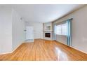 Cozy living room features wood-look floors, natural light, and a fireplace at 312 Manti Pl, Henderson, NV 89014