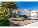 Inviting home with a two-car garage, mature landscaping, and a well-manicured lawn at 4421 Rodman Dr, Las Vegas, NV 89130