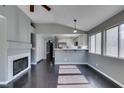 Open living room with a fireplace, dark wood floors, and a view into the bright kitchen at 4421 Rodman Dr, Las Vegas, NV 89130