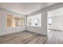 Bright living room featuring wood-look flooring, multiple windows, and an open layout perfect for entertaining guests at 4473 Oberlander Ave, North Las Vegas, NV 89031