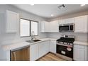 Bright kitchen featuring white cabinets, stainless steel appliances, and a large window for natural light at 4839 Englewood Ave, Las Vegas, NV 89139