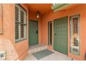 Inviting front entrance with dual green doors, decorative light fixture, and a welcoming tiled porch at 5323 Taravilla Cir, Las Vegas, NV 89146